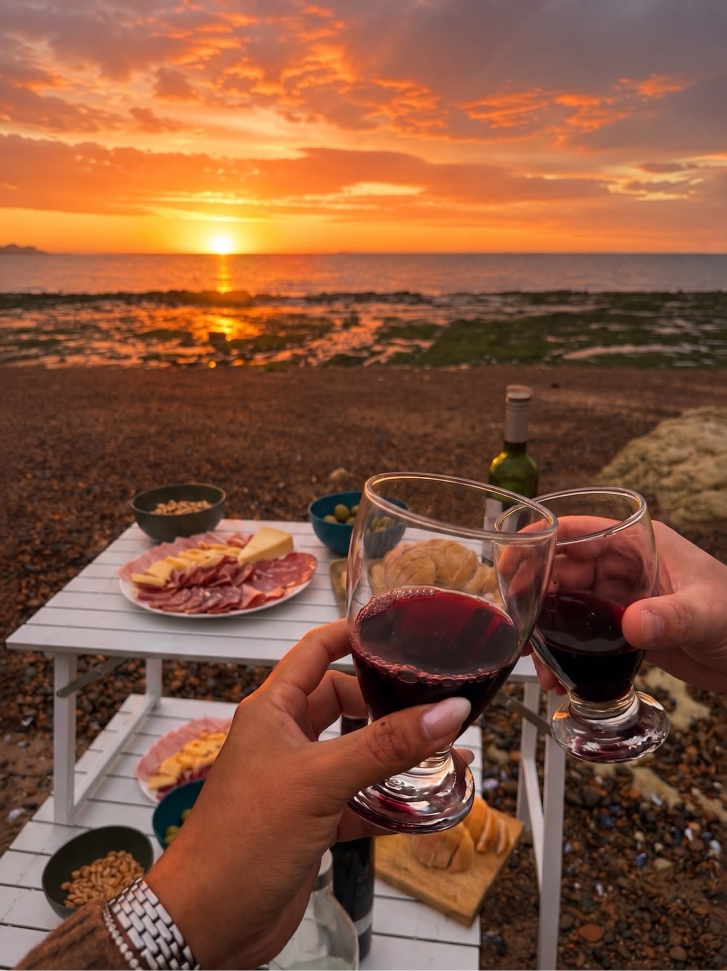 Patagonian platter with drinks by the sea, beside a warm campfire.